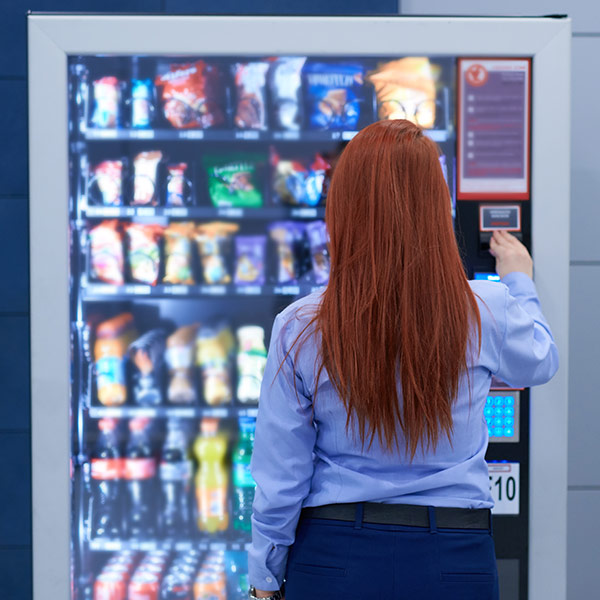 woman picking out a snack from vending machine